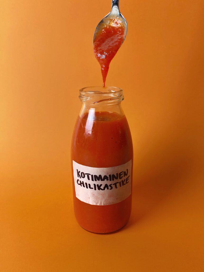 Chilikastike-scaled Kuvassa on chilikastiketta lasipullossa.